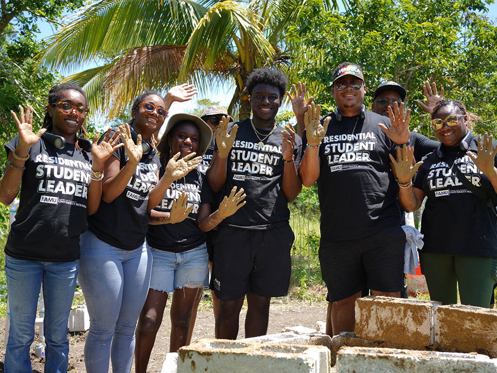 Florida A&M University student leaders and staff pause during community service efforts at Jacks River Primary School in St. Mary, Jamaica, where participants helped install a hydroponic gardening system as part of an international service-learning experience focused on leadership, sustainability and cultural exchange. (Photo Courtesy: Ernest Nelfrard)