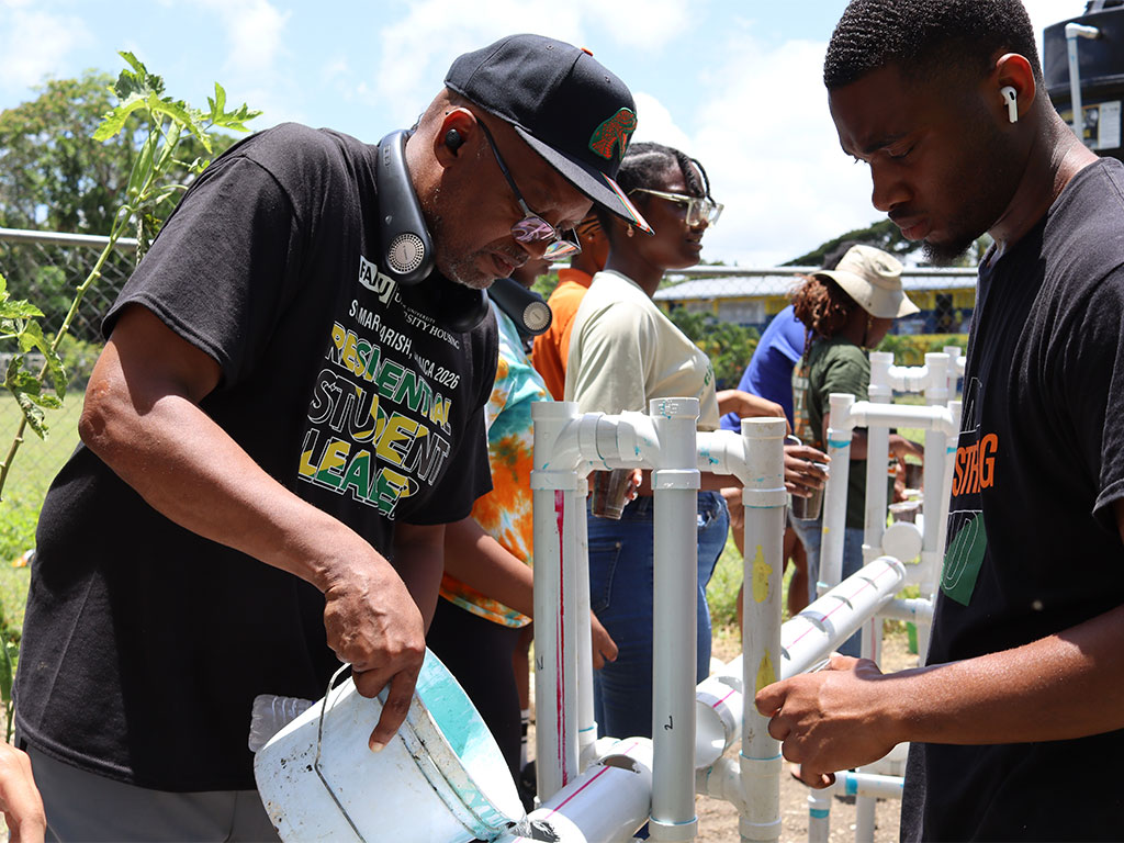 Vice President for Student Affairs William Hudson Jr., left, works alongside Florida A&M University students during the installation of a hydroponic gardening system at Jacks River Primary School in St. Mary, Jamaica, as part of a weeklong international service-learning experience led by the Office of University Housing and Division of Student Affairs. (Photo Courtesy: Ernest Nelfrard)