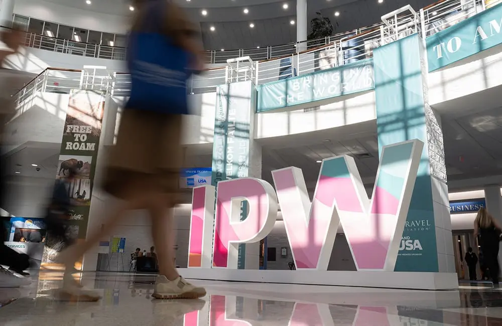 IPW 2026 sign with blurred people walking
