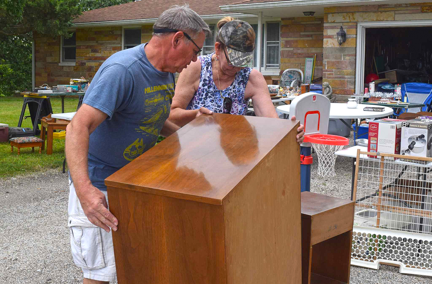 Brother and sister David West and Karol Hill set down a heavy cabinet ahead of the 2024 city-wide yard sale. The deadline to participate as a seller in this year's sale is May 8.
