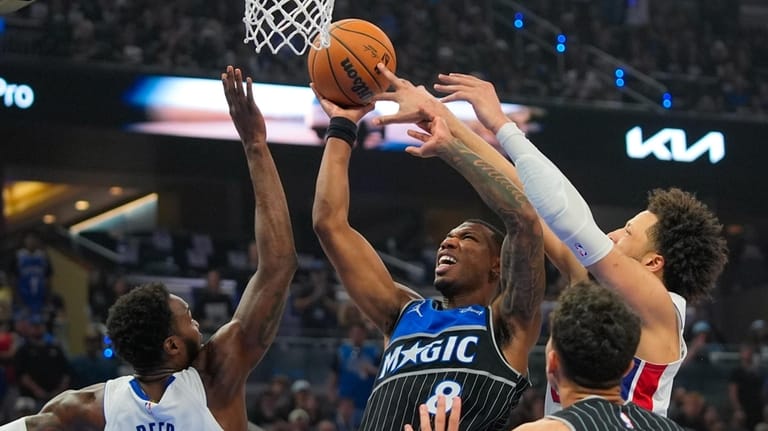 Orlando Magic forward Jamal Cain, center, struggles to get off...