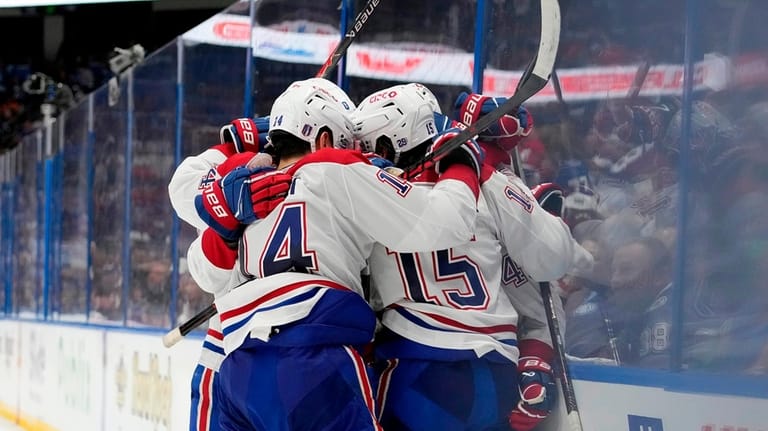 Montréal Canadiens center Alex Newhook (15) is mobbed by teammates,...