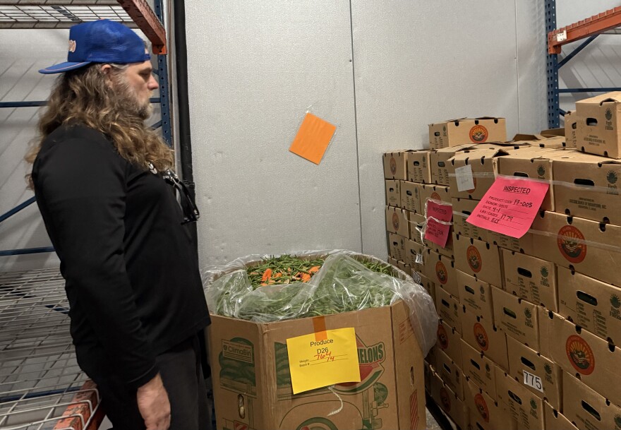 Bread of the Mighty Food Bank volunteer engagement manager Philip Guiry overlooks a container of produce in the food bank warehouse. “You can’t change the world, but you can change your community,” Guiry said.