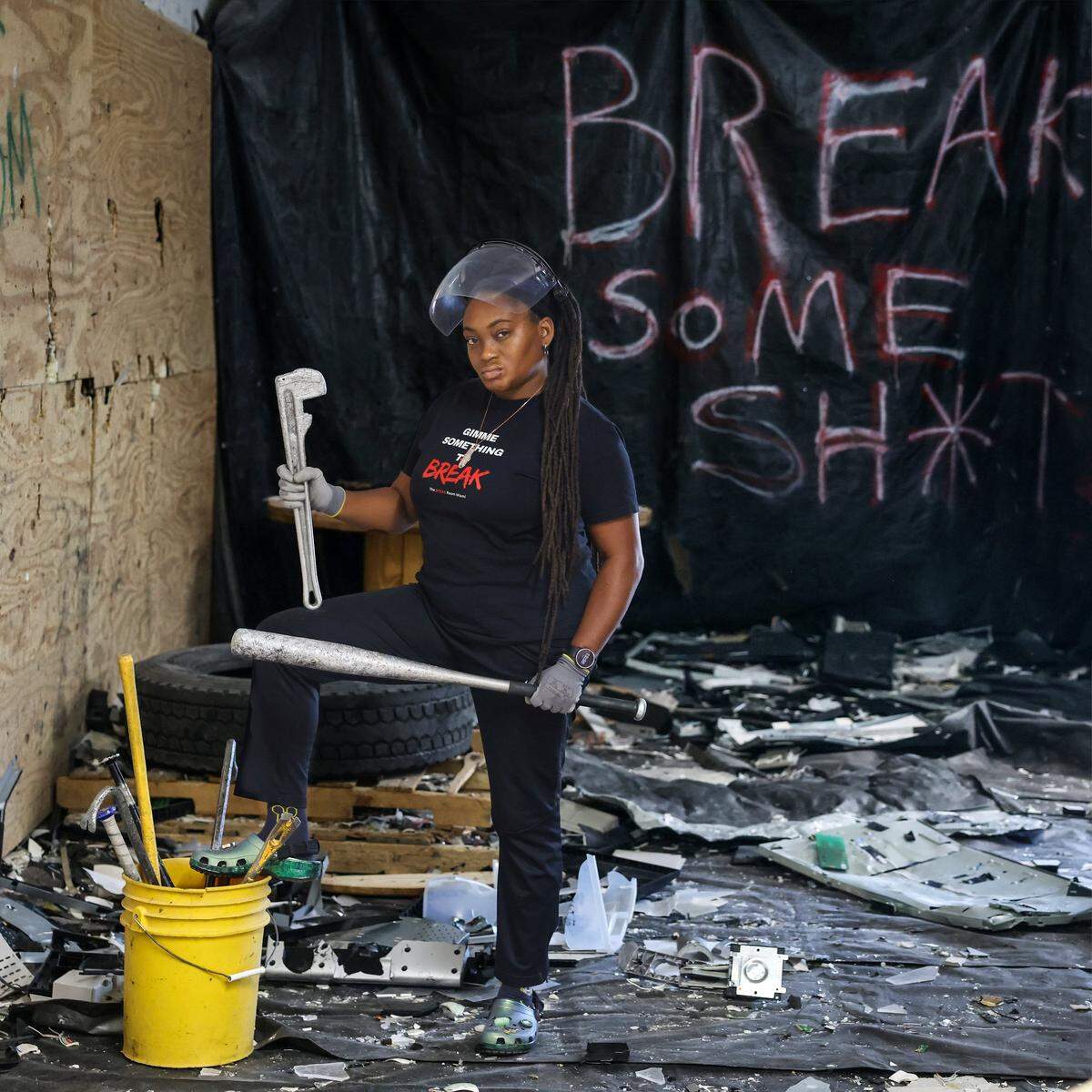 Christina Brown, 40, owner of Break Room Miami, stands inside one of the business's two rage rooms holding some of the tools customers use to smash objects, Thursday, May 7, 2026, in Miami.