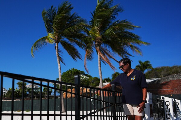 Underwater Adventure Seekers member Dr. Melody Garrett pours a libation of white rum onto the sand at a memorial on the site where hundreds of Africans who died in 1860 after being rescued from three slave ships were buried, on Higgs Beach in Key West, Fla., Saturday, May 9, 2026. (AP Photo/Rebecca Blackwell)