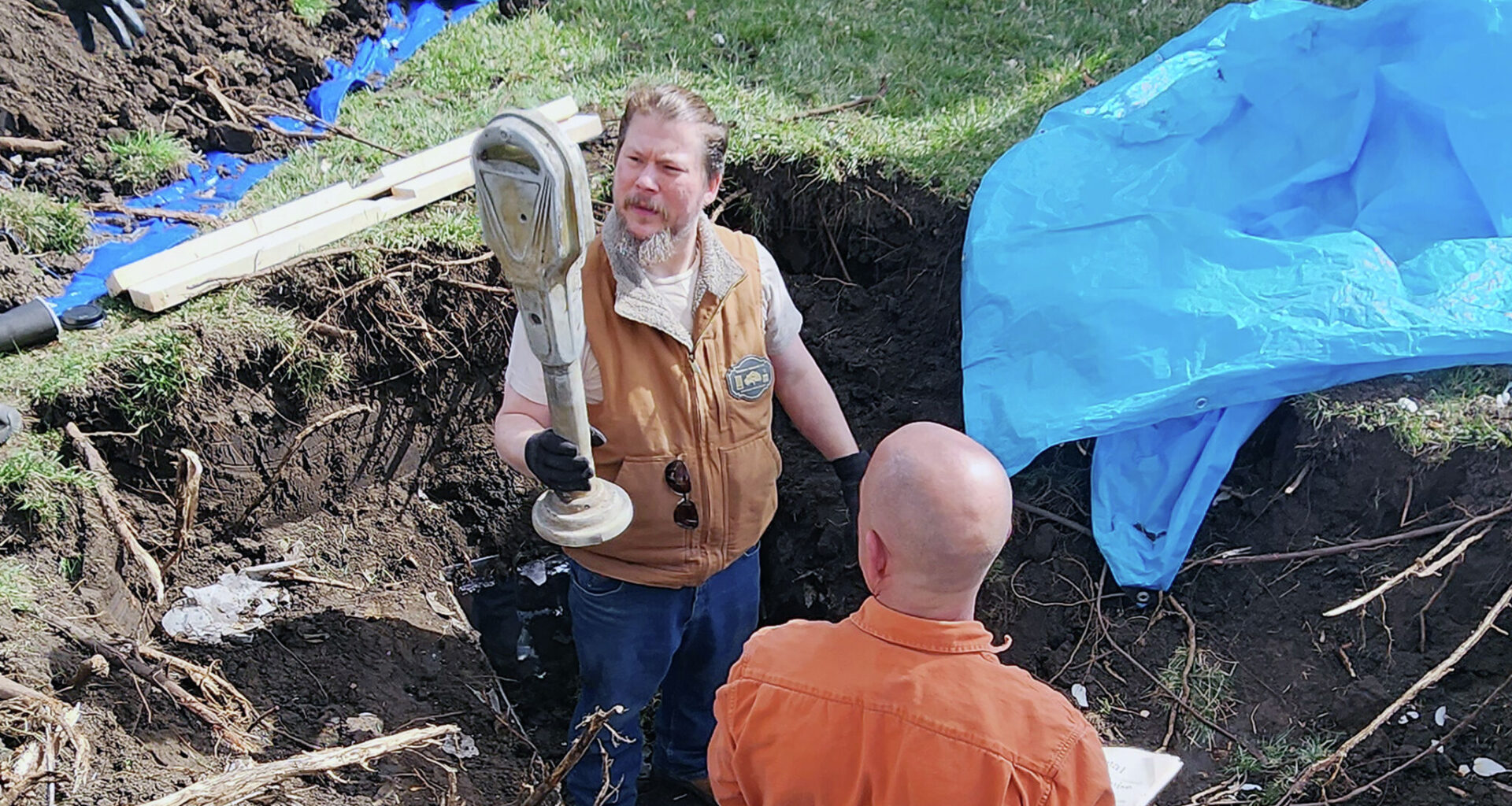 Kale Schleiter (left) holds a parking meter as he and city employee John Green pull the contents from a time capsule on the downtown Jacksonville square. The time capsule, sealed in 1975 as part of the city's sesquicentennial celebrations, was opened in 2025 as part of the city's bicentennial celebrations. A new time capsule will be buried next week.