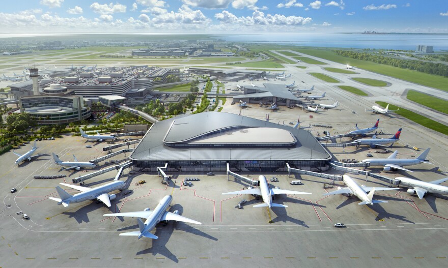 A rendering shows a new airport terminal connected to Tampa International Airport. Several planes surround the sleek, gray terminal, and the sky is blue with white clouds.