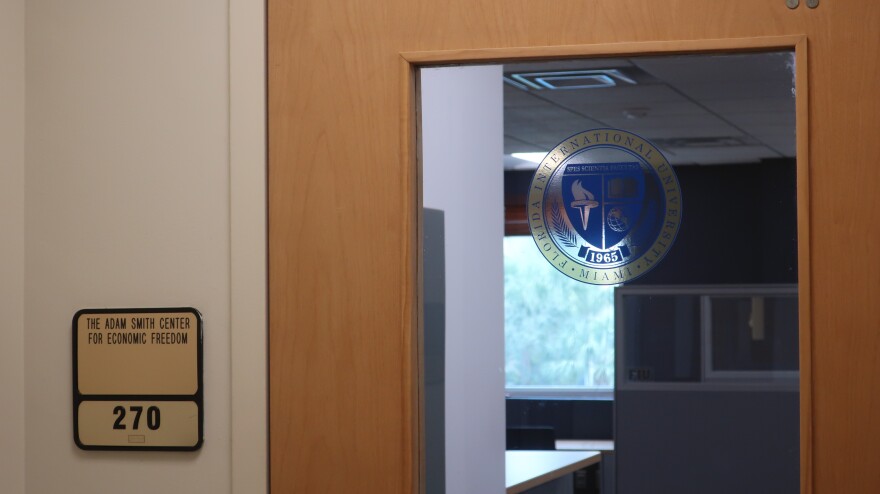 A placard that says 207 and "Adam Smith Center for Economic Freedom" in front of a transparent door