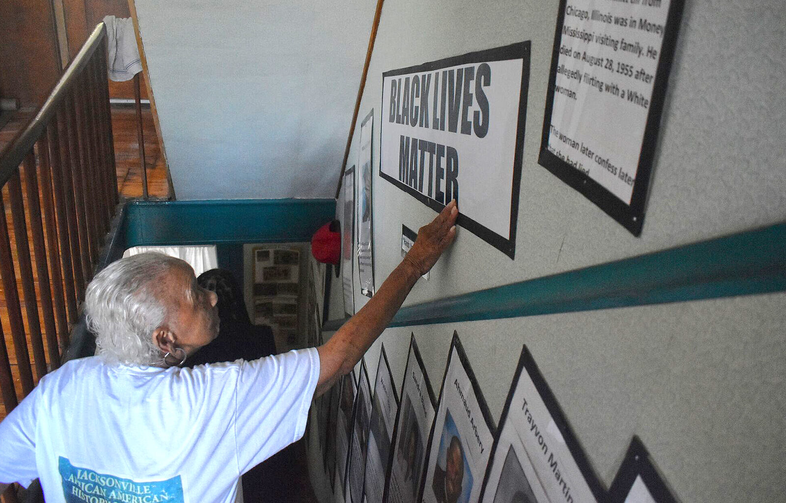 Ruth Linear, founding director of the Jacksonville African American History Museum, touches a sign that says "Black Lives Matter." Linear has contributed much of the research at the museum.