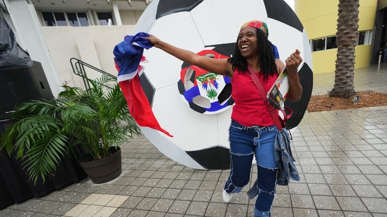 Odeline Paul dances with a Haitian flag at a Haitian...