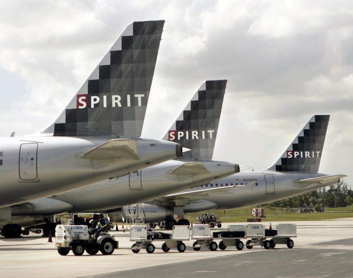 In 2007, a Spirit Airlines baggage handler drives carts past three Spirit jets outside Terminal 4 at Fort Lauderdale-Hollywood International Airport.