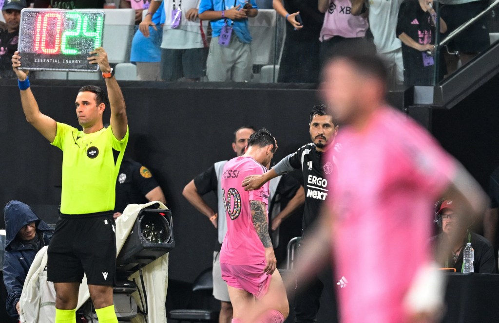 Lionel Messi leaving the field during a soccer match due to injury.