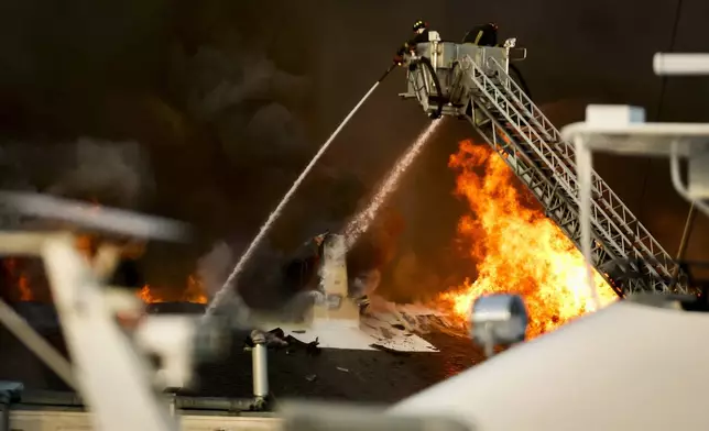 Firefighters battle a fire at the University of South Florida campus Saturday, May 2, 2026, in St. Petersburg.=, Fla. (Luis Santana/Tampa Bay Times via AP)