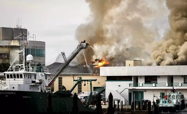 Firefighters work to extinguish a fire at the University of South Florida campus Saturday, May 2, 2026, in St. Petersburg, Fla. (Luis Santana/Tampa Bay Times via AP)