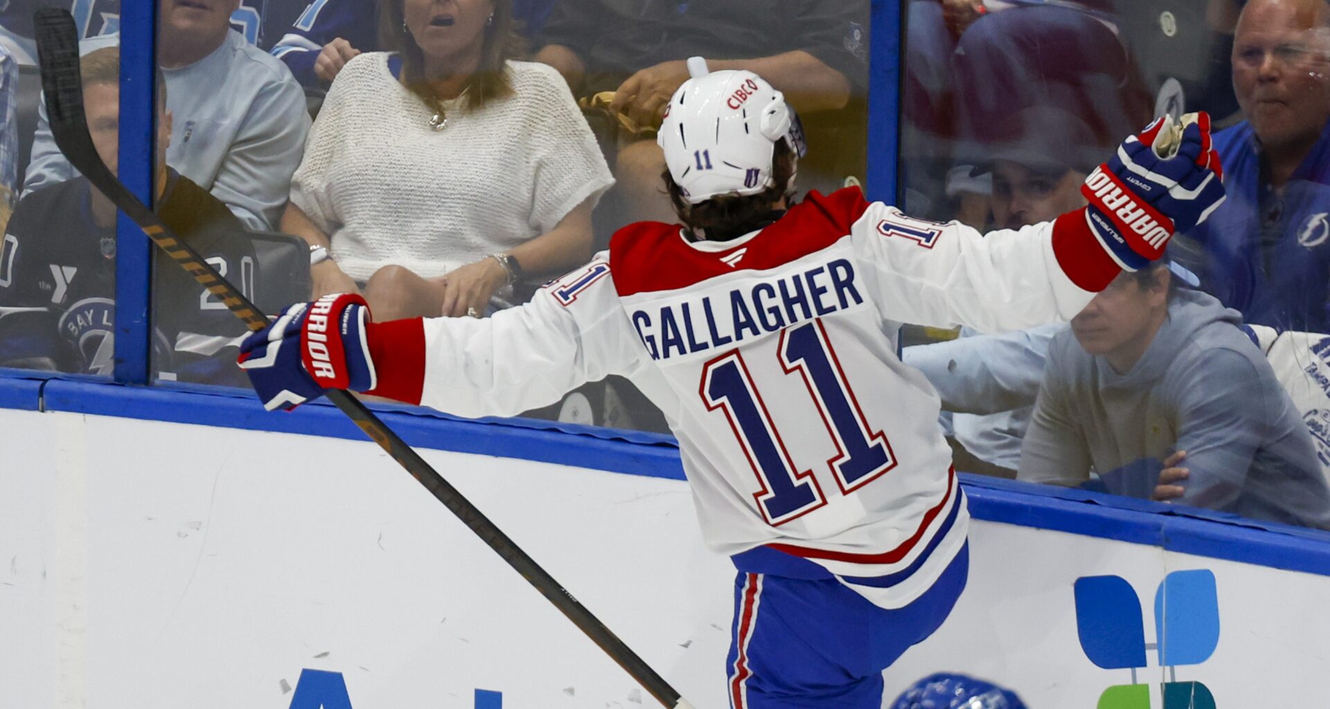 Brendan Gallagher extends his arms out in celebration as he faces unimpressed Tampa fans on the other side of the glass.