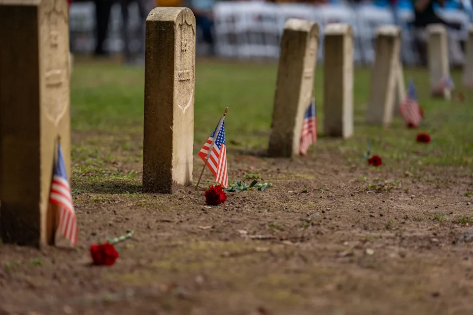 Small American flags and reg carnations are placed at the base of the headstones of Union soldiers in the Old City Cemetery on Emancipation Day.