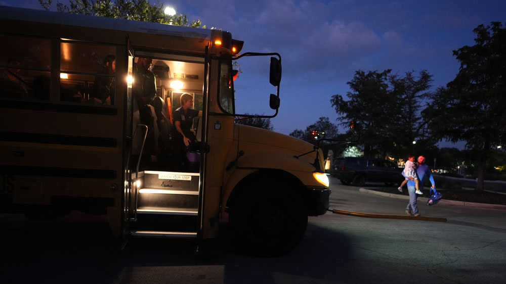 Students arrive to catch an early morning school bus, Oct. 9, 2025, in San Antonio. (AP Photo/Eric Gay)