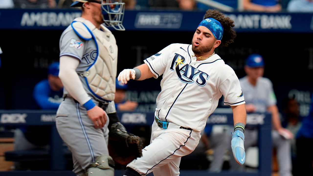 Tampa Bay Rays' Jonathan Aranda, right, scores in front of Toronto Blue Jays catcher Tyler Heineman on an RBI double by Jonny DeLuca during the fourth inning of a baseball game Wednesday, May 6, 2026, in St. Petersburg, Fla. (AP Photo/Chris O'Meara)