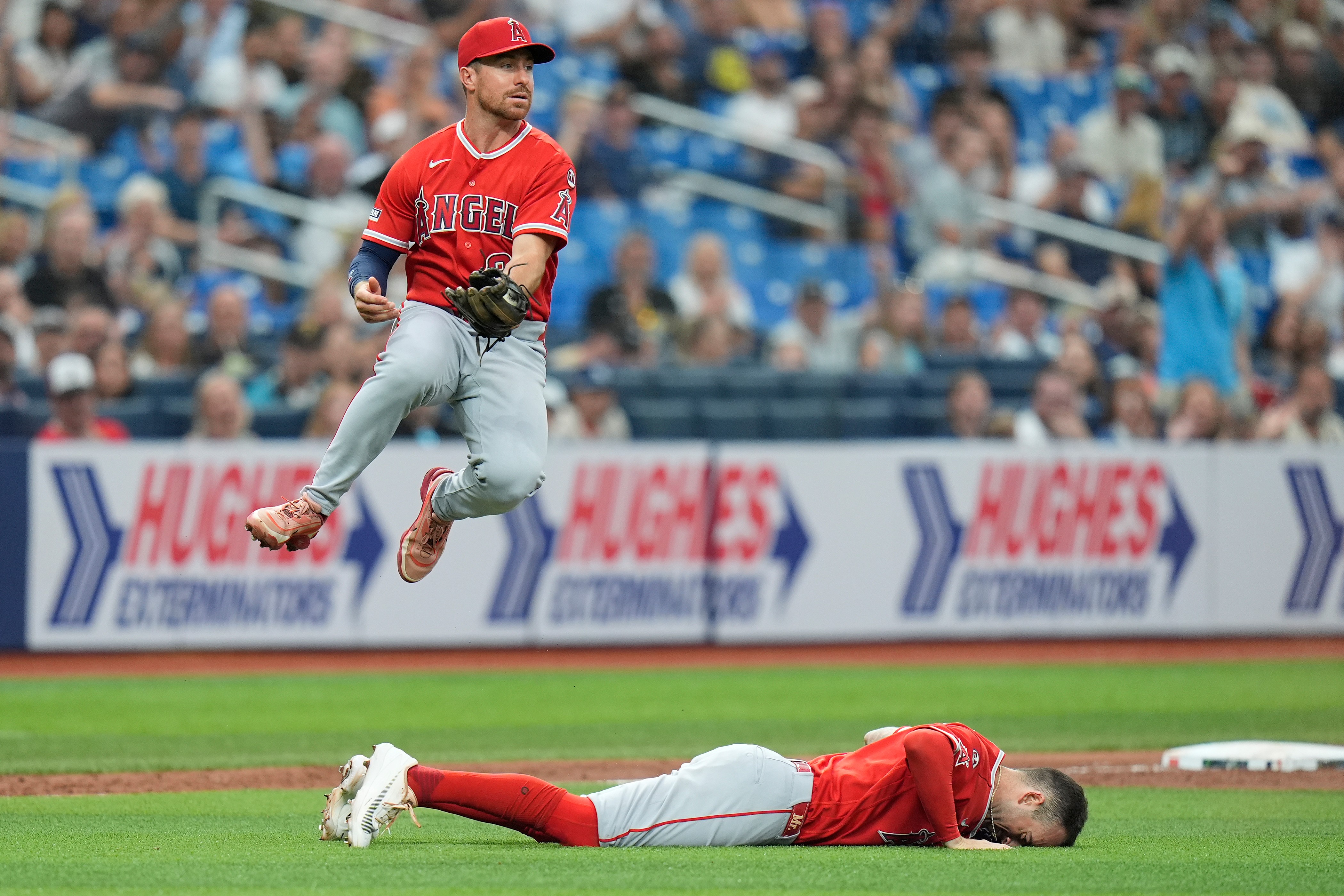 Angels third baseman Donovan Walton leaps over shortstop Zach Neto...