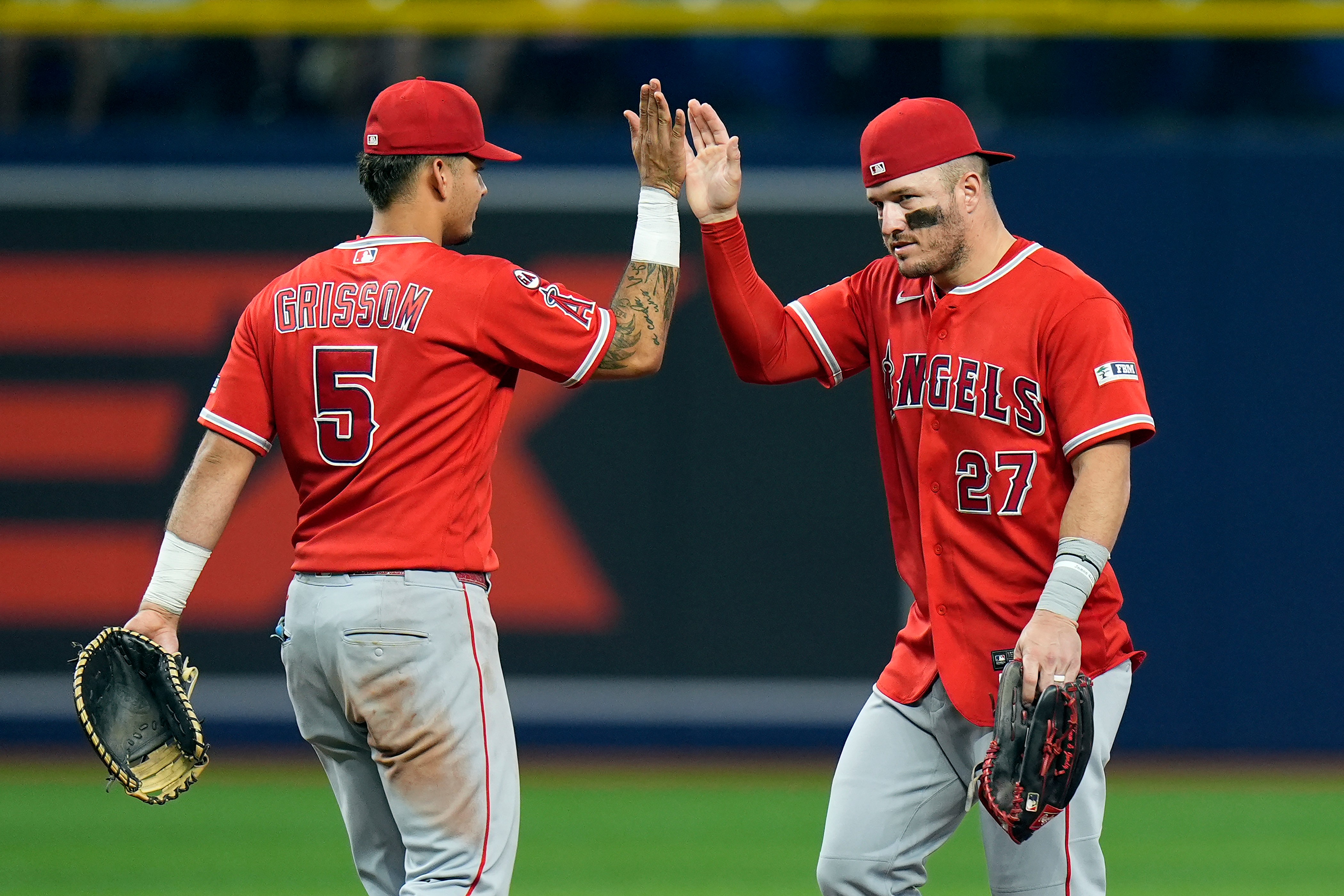 Angels’ Mike Trout (27) celebrates with Vaughn Grissom (5) after...
