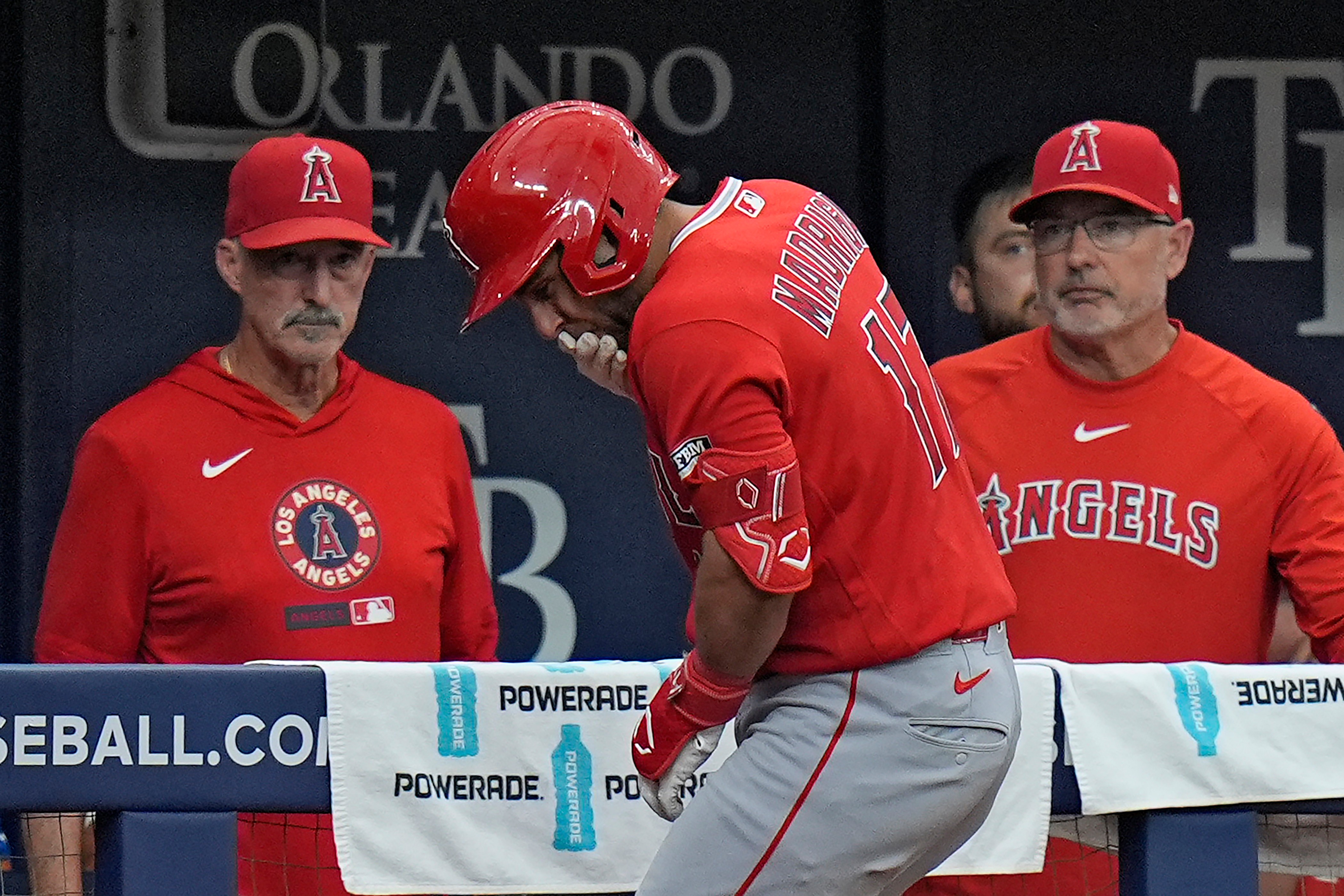 Angels’ Nick Madrigal, center, reacts after getting hit by a...