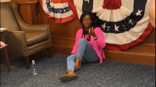 Rep. Angie Nixon sitting on the floor