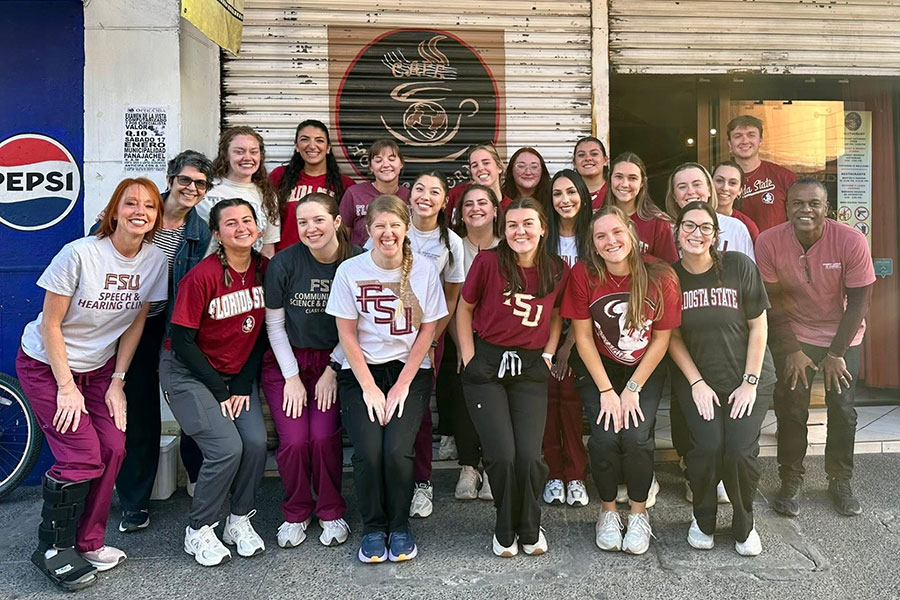 A group of people posing in front of a restaurant in Guatemala.