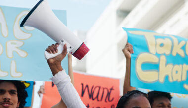 Strike, people and hands with megaphone in city for inflation, human rights and cost of living. Speaker, community and group in protest with bullhorn for rally, justice or higher wages for change