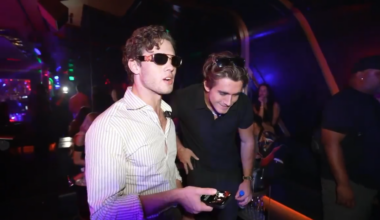 A photo of a man wearing sunglasses inside a club.