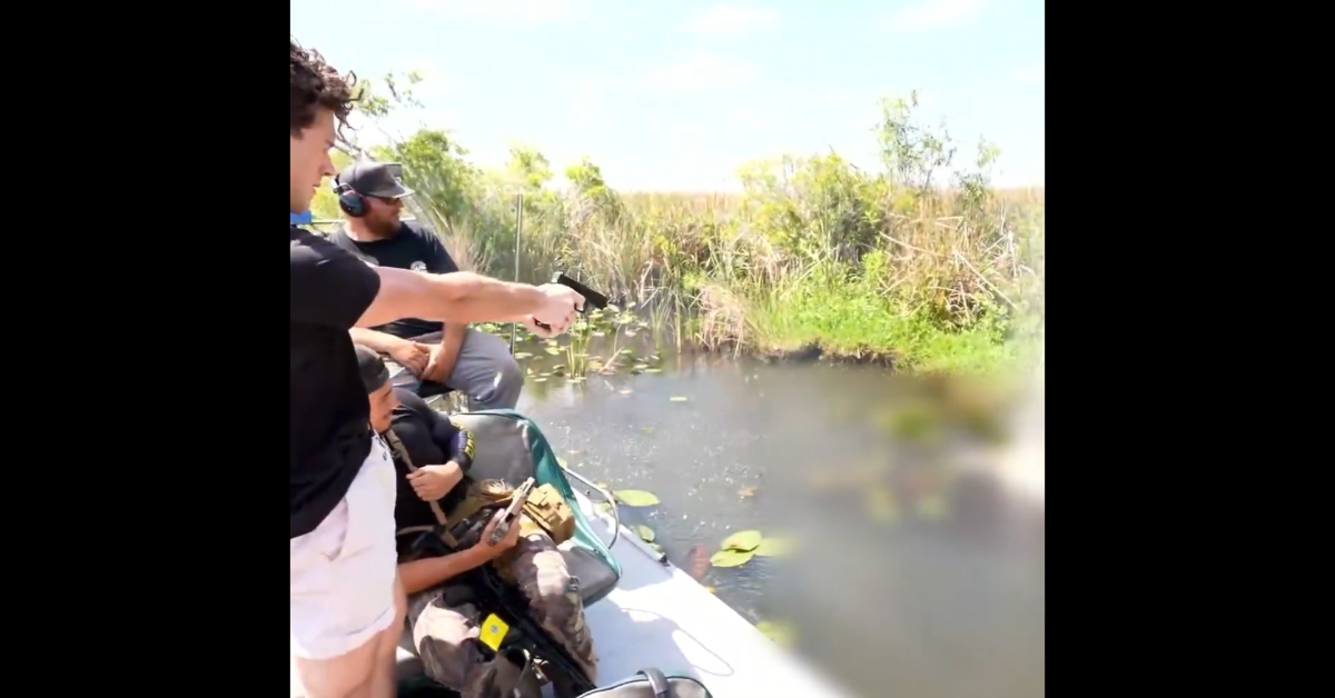 A screenshot of a video showing a man shooting at an object in the water.