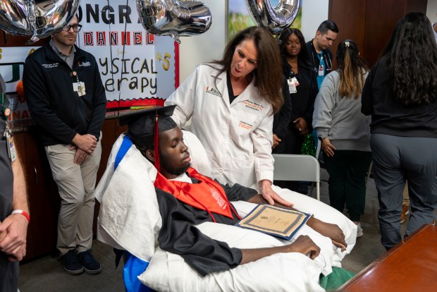 Daniel Alexis and his high school diploma. (Courtesy of UHealth)