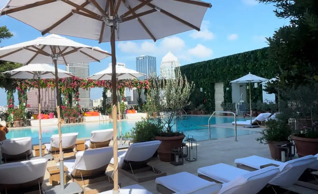 lounge chairs arranged around a rooftop pool in the daytime