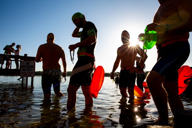 Swimmers enter the water of Lake Cane during the ninth annual Easter Eat, Pray, Swim event at Lucky's Lake Swim in Orlando on Sunday, April 21, 2019. (Patrick Connolly/Orlando Sentinel)