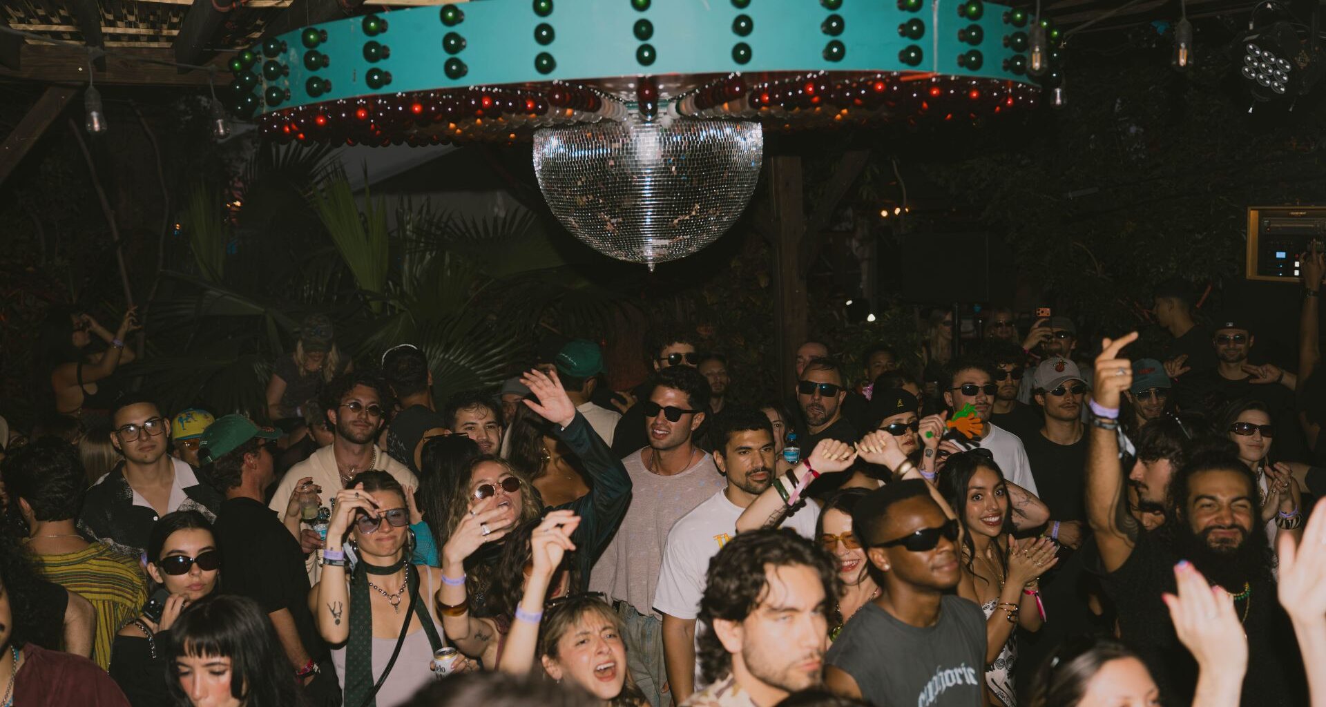 Photo of a crowd dancing under a disco ball in Miami.