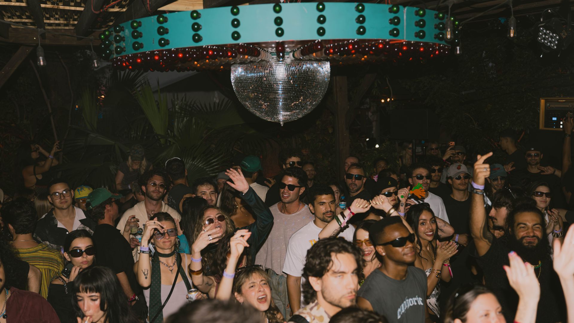 Photo of a crowd dancing under a disco ball in Miami.