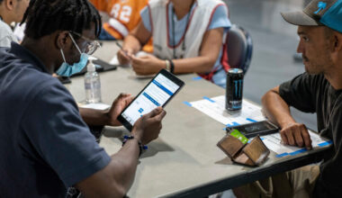FEMA representatives take information from people displaced by Hurricane Ian at a shelter in Estero, Fla. Credit: Thomas Simonetti for The Washington Post/Getty Images