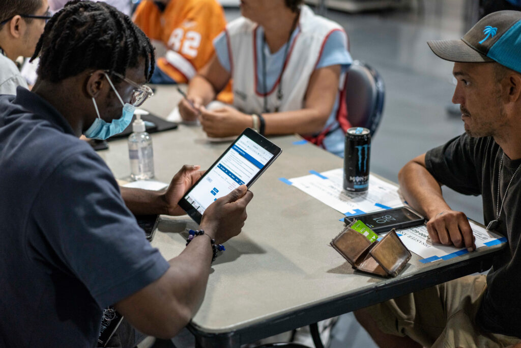 FEMA representatives take information from people displaced by Hurricane Ian at a shelter in Estero, Fla. Credit: Thomas Simonetti for The Washington Post/Getty Images