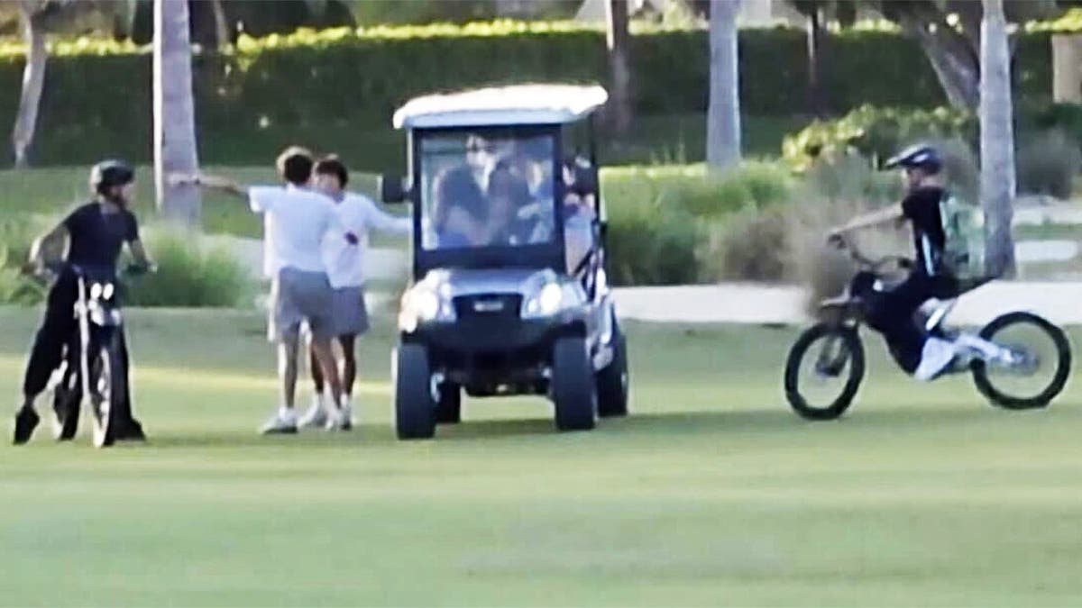Teens on golf course on motorized vehicles.