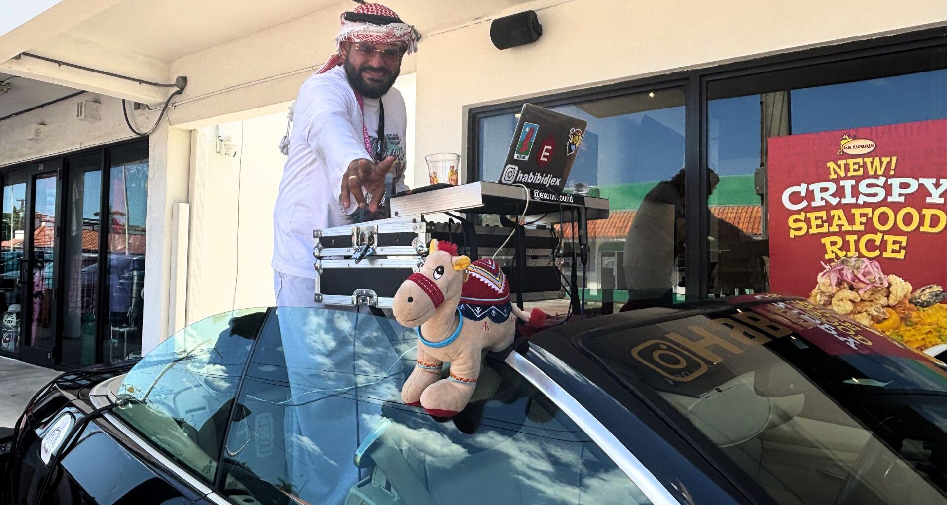 Photo of a DJ in Miami outside La Granja Restaurant inside a convertible BMW.