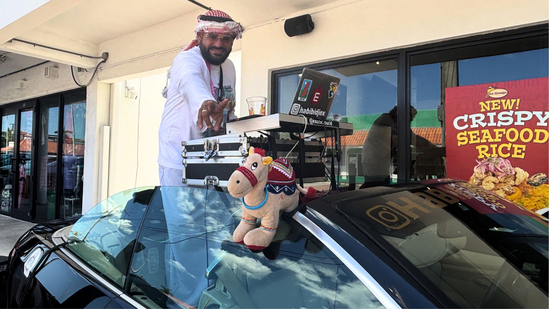 Photo of a DJ in Miami outside La Granja Restaurant inside a convertible BMW.