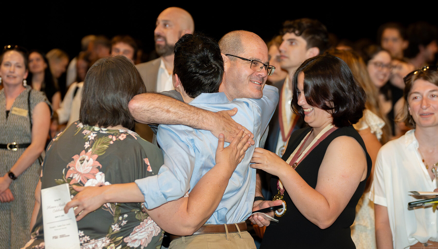 A father embraces his son during the honors medallion ceremony