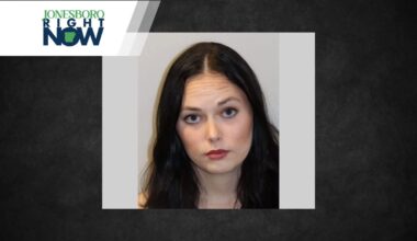 Portrait of a young woman with dark hair and neutral expression, light gray background, positioned within a gray frame and Jonesboro Right Now banner above left.