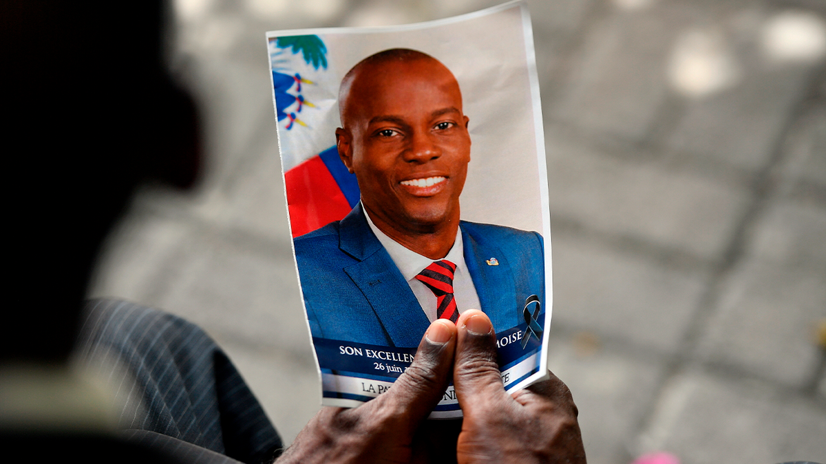 A person holds a photo of late Haitian President Jovenel Moise