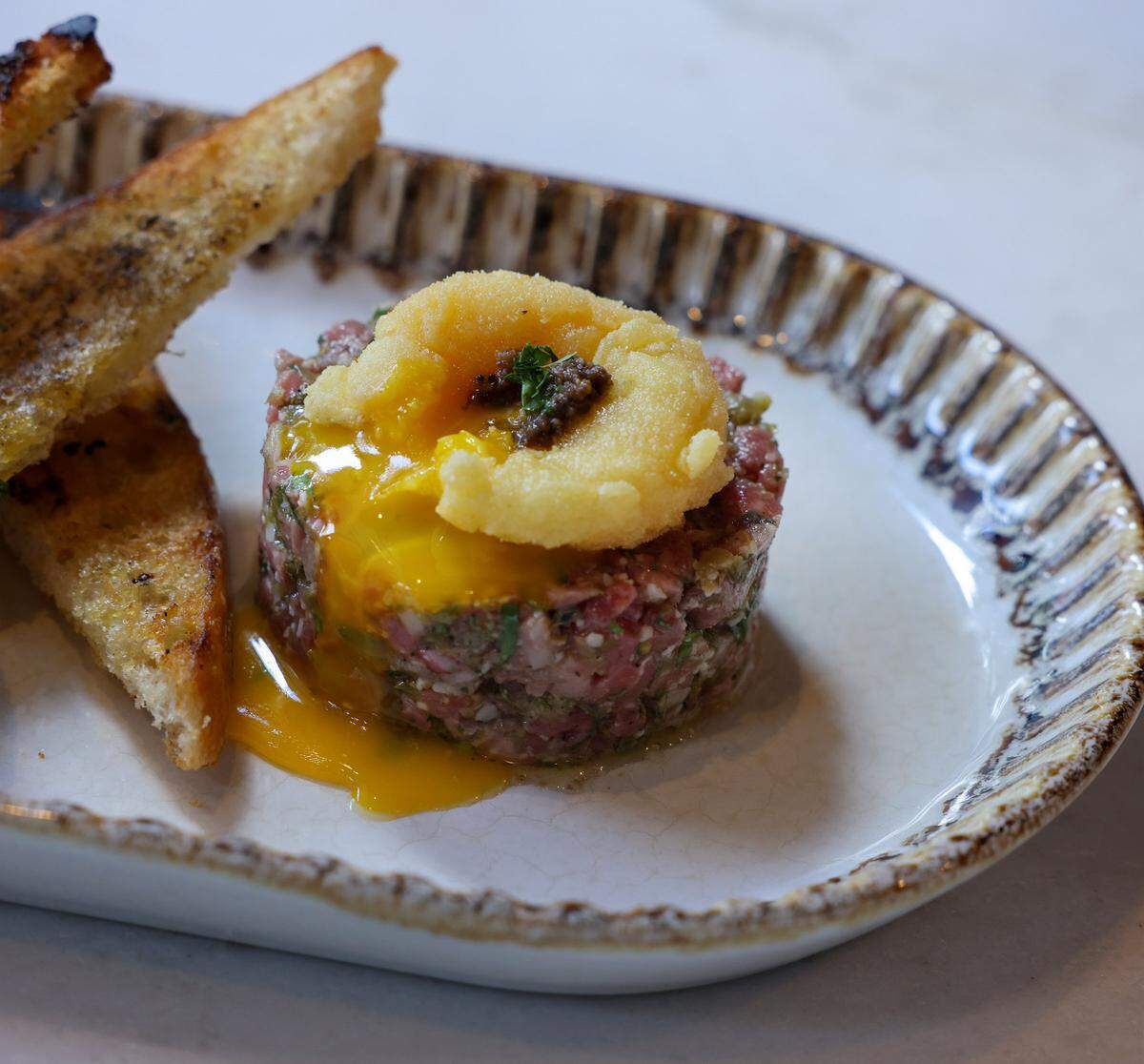 Pictured is Buchan's dish steak tartare with a crispy egg yolk, and black truffle is on the menu on Tuesday, May 19, 2026.