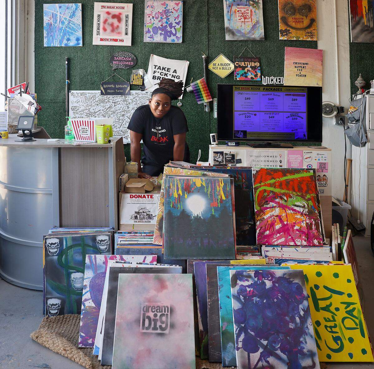 Christina Brown, 40, owner of Break Room Miami, stands at the front counter where art made in the splatter room is displayed, Thursday, May 7, 2026, in Miami.