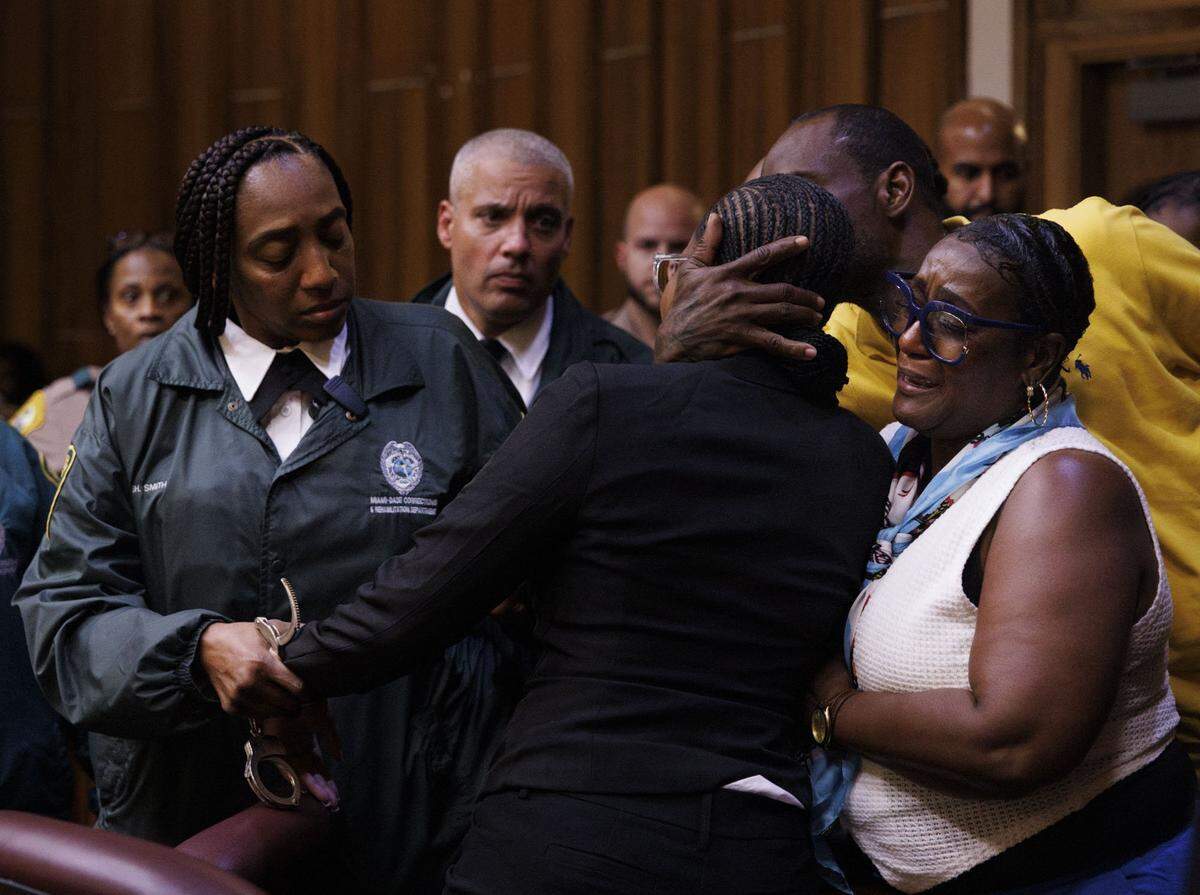 Jahara Malik, now 18, center, is hugged by her family while a corrections officer puts handcuffs on her after she is sentenced to 17 years in prison, after pleading guilty to the manslaughter of Yahkeim Lollar previously, in court Tuesday, May 5, 2026, at Richard E. Gerstein Justice Building in downtown Miami, Fla.