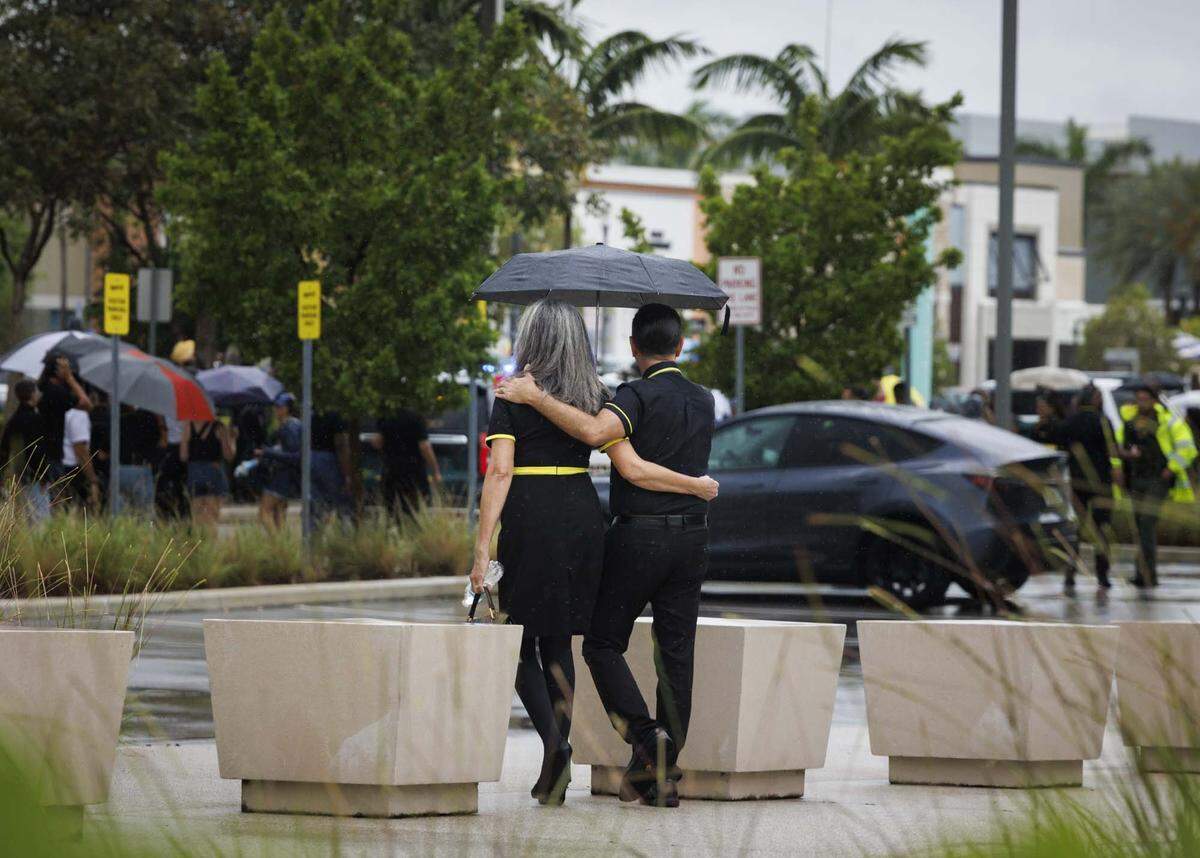 Two former Spirit Airlines employees, who were recently left without jobs as the airlines closed Saturday, walk to the gathering outside of headquarters on Monday, May 4, 2026, in Dania Beach, Fla. 