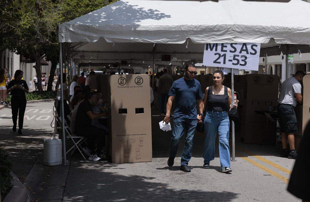 People walk out of the tent outside the Columbian Consulate after voting in the streets on Sunday, May 31, 2026, in Coral Gables, Fla.