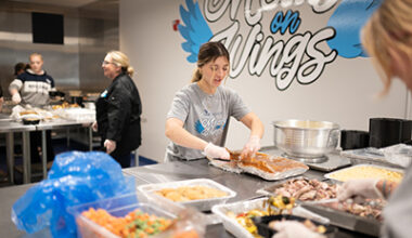 Woman preparing food on large table.