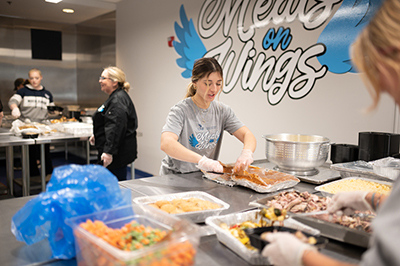 Woman preparing food on large table.
